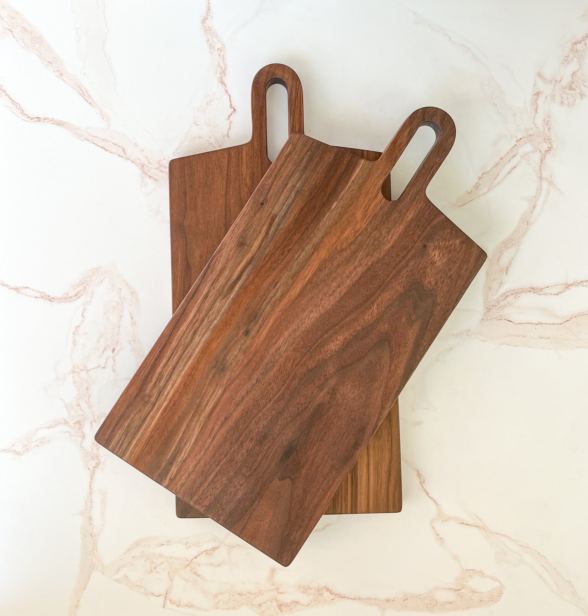 Handmade modern looking dark wooden large rectangle charcuterie/cutting board with rounded handle made by Camino Woodshop in Milwaukee, WI