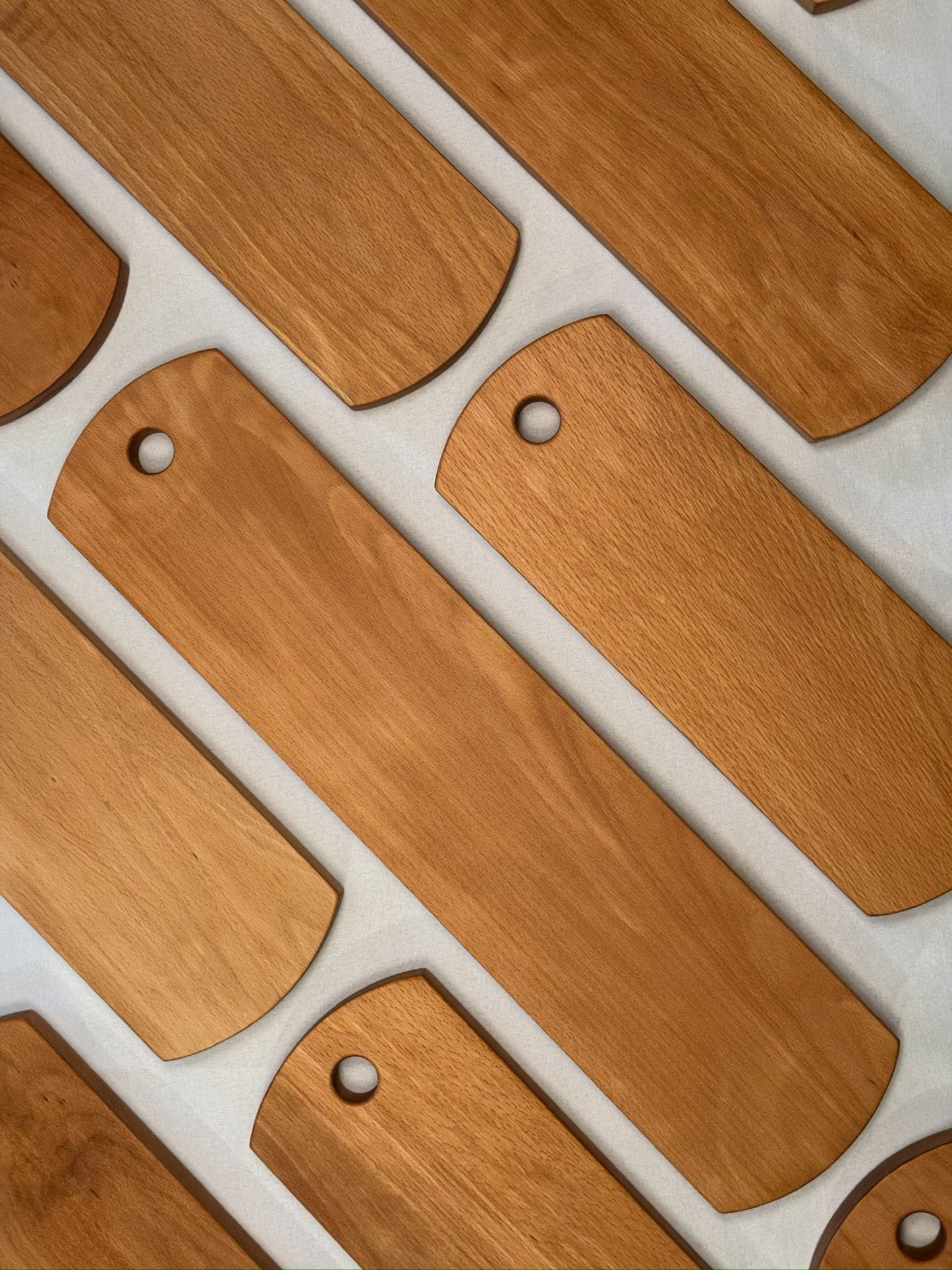 wooden beech charcuterie board with hole on white background 