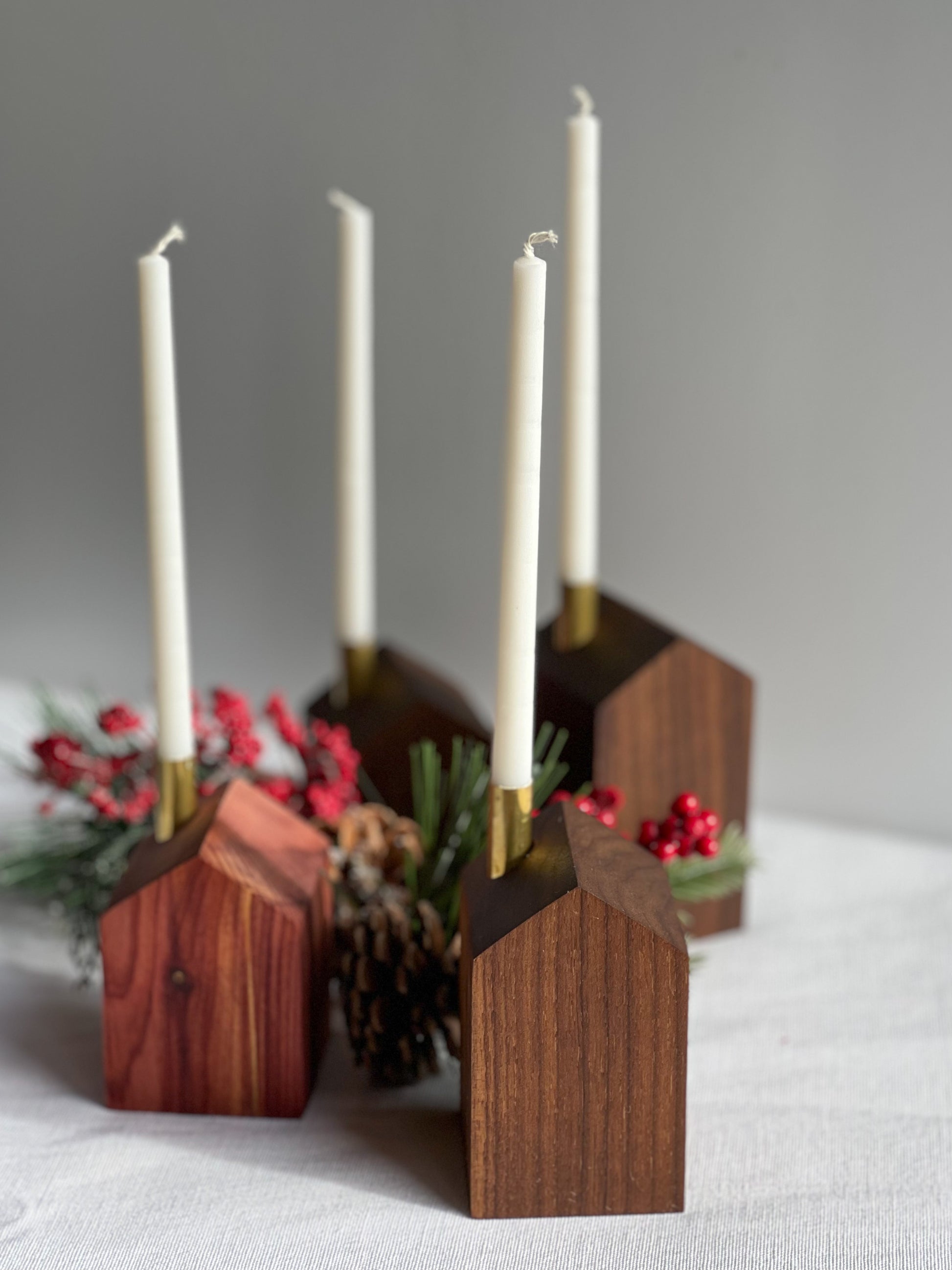 4 beautiful handcrafted wooden modern advent wreath and candle holders surrounded with pinecones and holly, a gorgeous Christmas decoration or gift made by Camino Woodshop