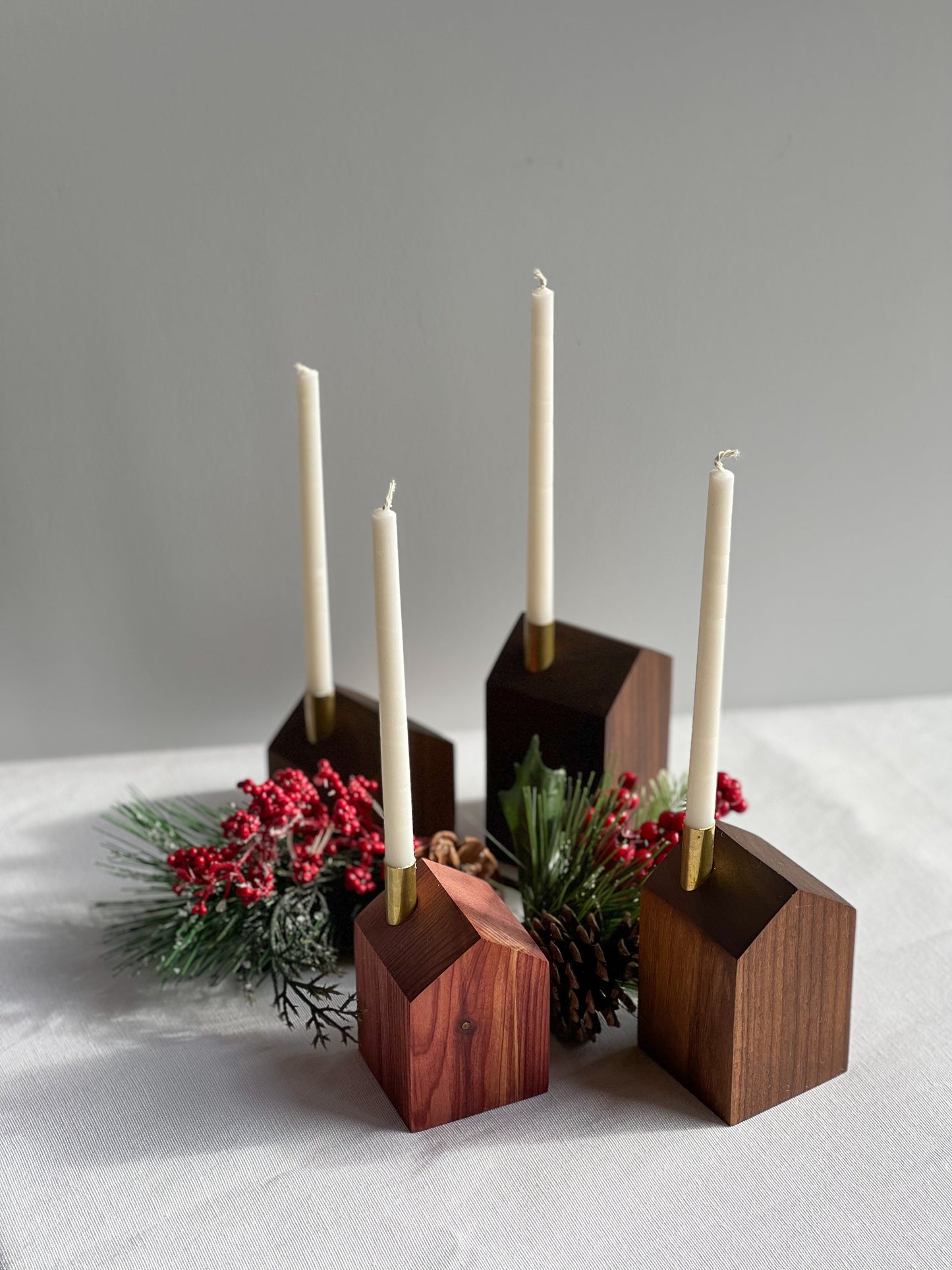 4 beautiful handcrafted wooden modern advent wreath and candle holders surrounded with pinecones and holly, a gorgeous Christmas decoration or gift made by Camino Woodshop