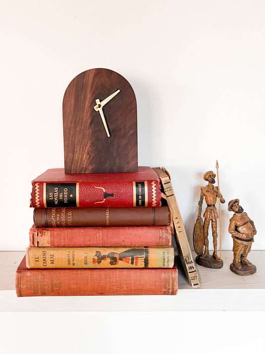 Handmade wooden rounded top mid century modern desk or shelf decor clock resting on a stack of vintage books