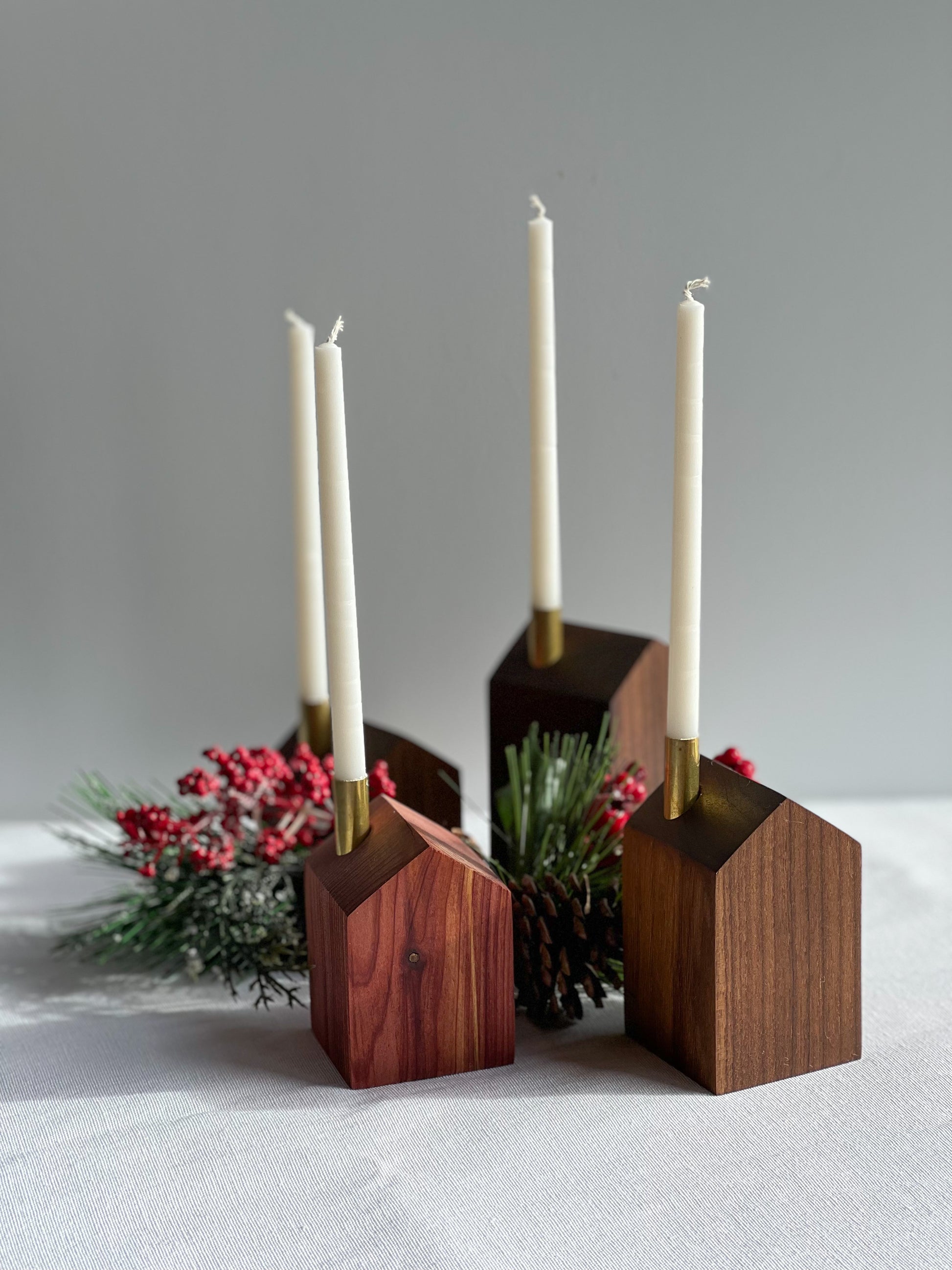 4 beautiful handcrafted wooden modern advent wreath and candle holders surrounded with pinecones and holly, a gorgeous Christmas decoration or gift made by Camino Woodshop